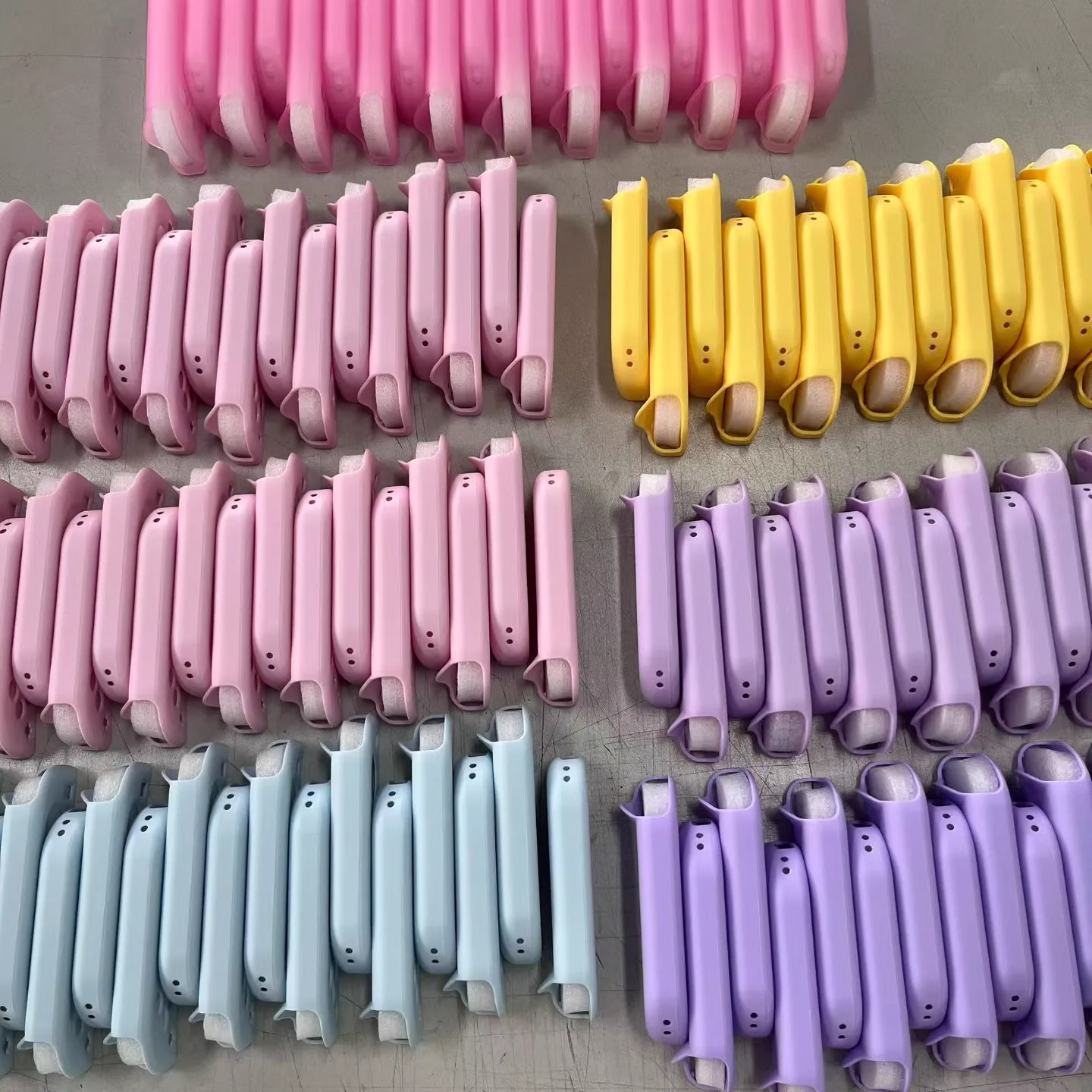 Rows of pastel pink, yellow, blue and purple controller shells during production